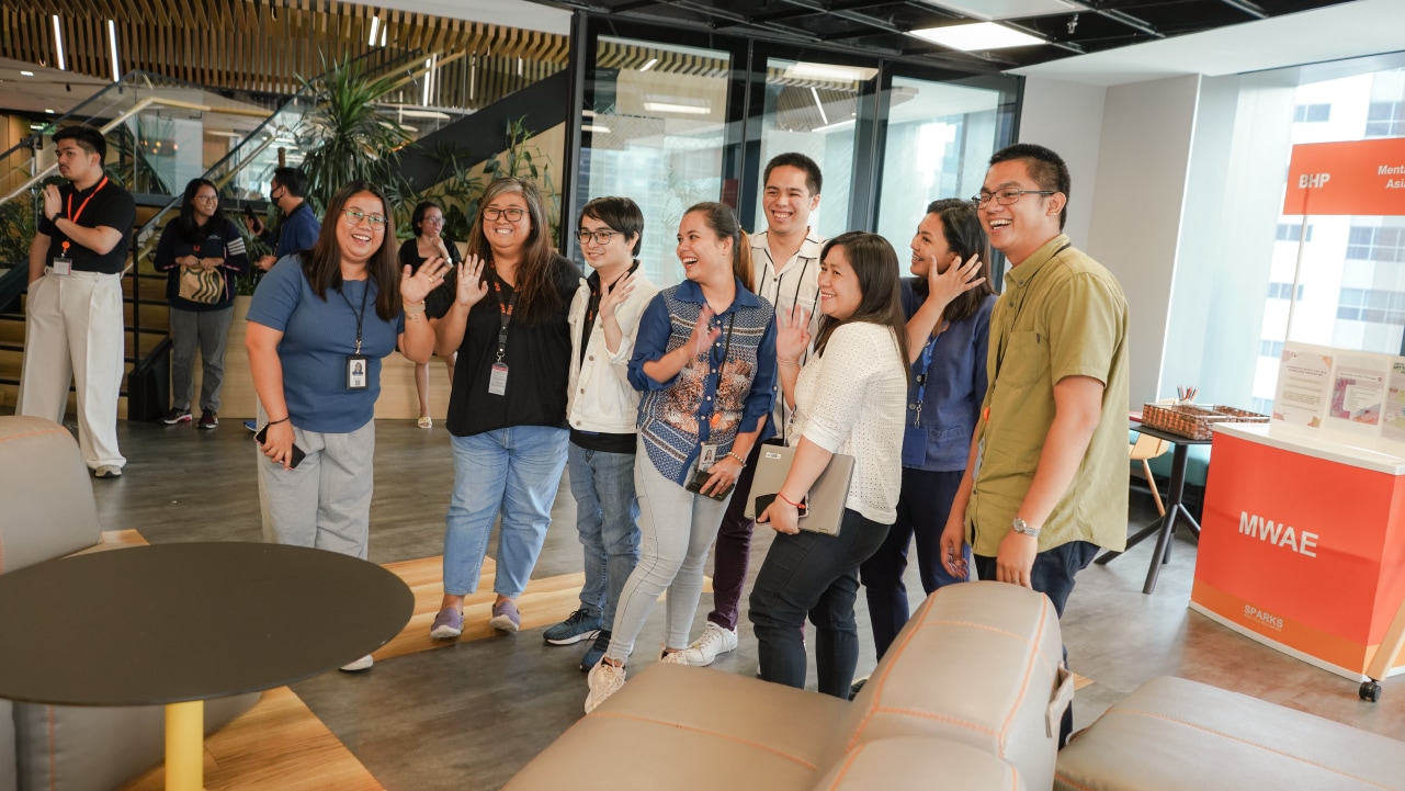 Group of people standing in BHP office smiling for team photo 